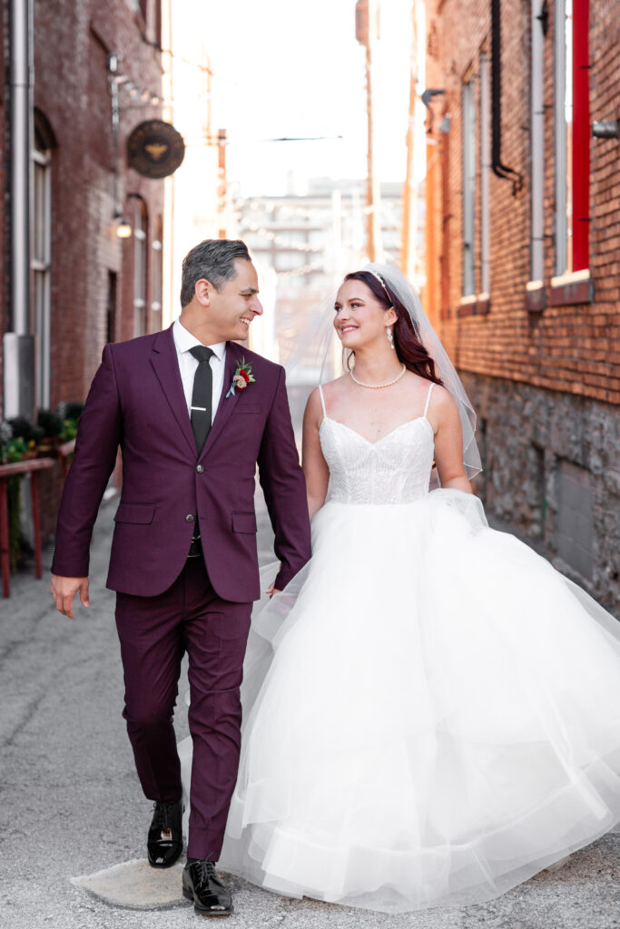 couple walk down the alley in their wedding attire